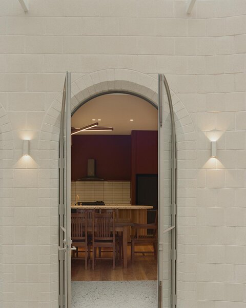 Arched doorways conceal windows and doors, offering seemingly secret passageways into the homes interior.