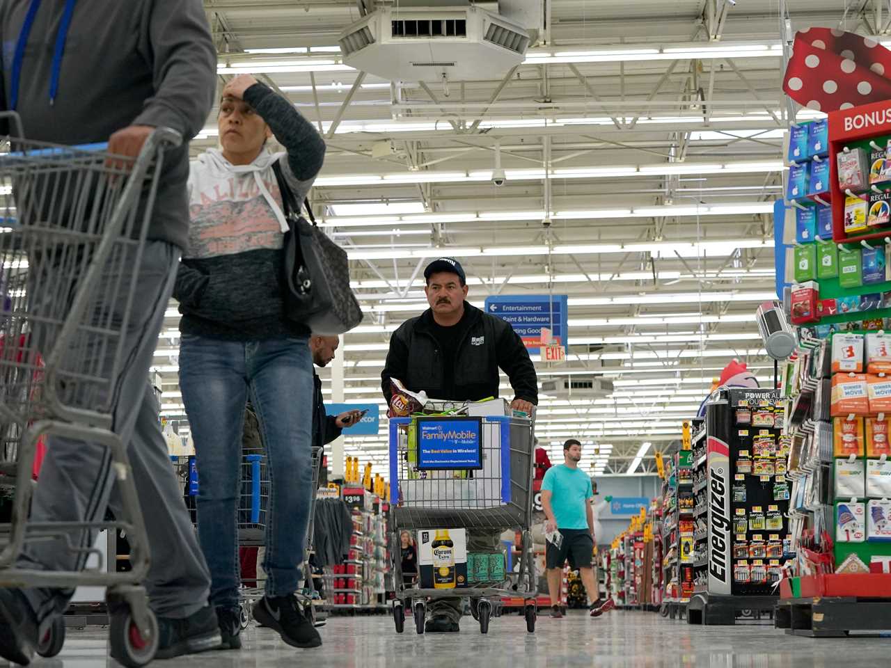 Shoppers walk down an aisle at a Walmart Supercenter Friday, Nov. 9, 2018, in Houston.