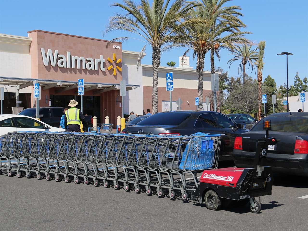 Carts in parking lot are being pushed by CartManager XD, a shopping cart pusher, to make cart retrieval more efficient and safe.