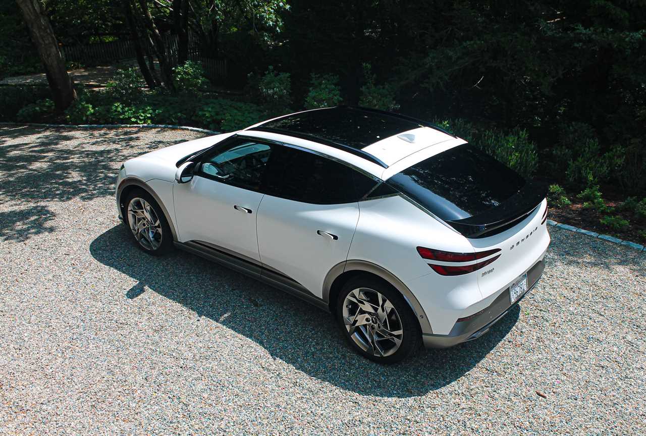 The Genesis GV60 electric SUV, with green trees in the background.