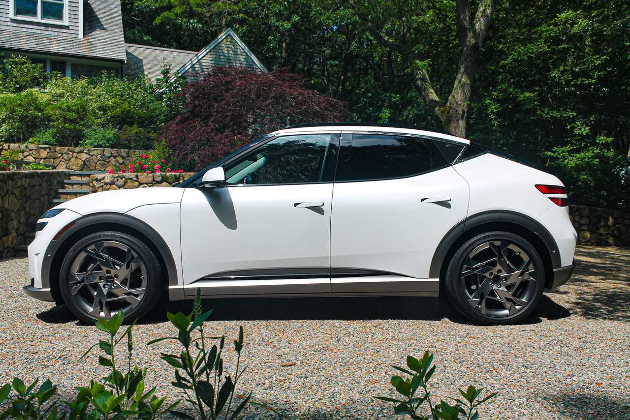 The Genesis GV60 electric SUV, with green trees in the background.