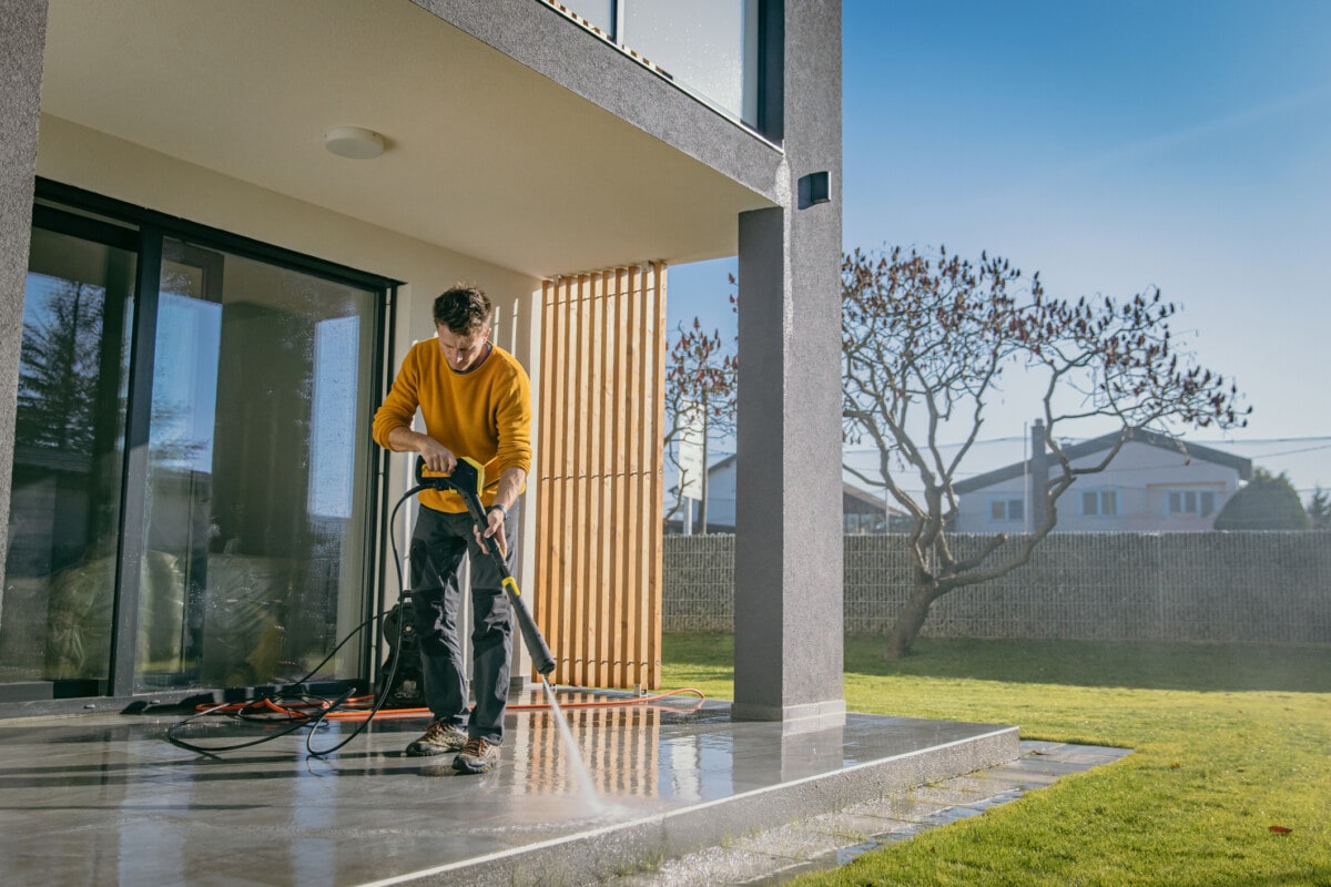 Homeowner pressure washing a patio