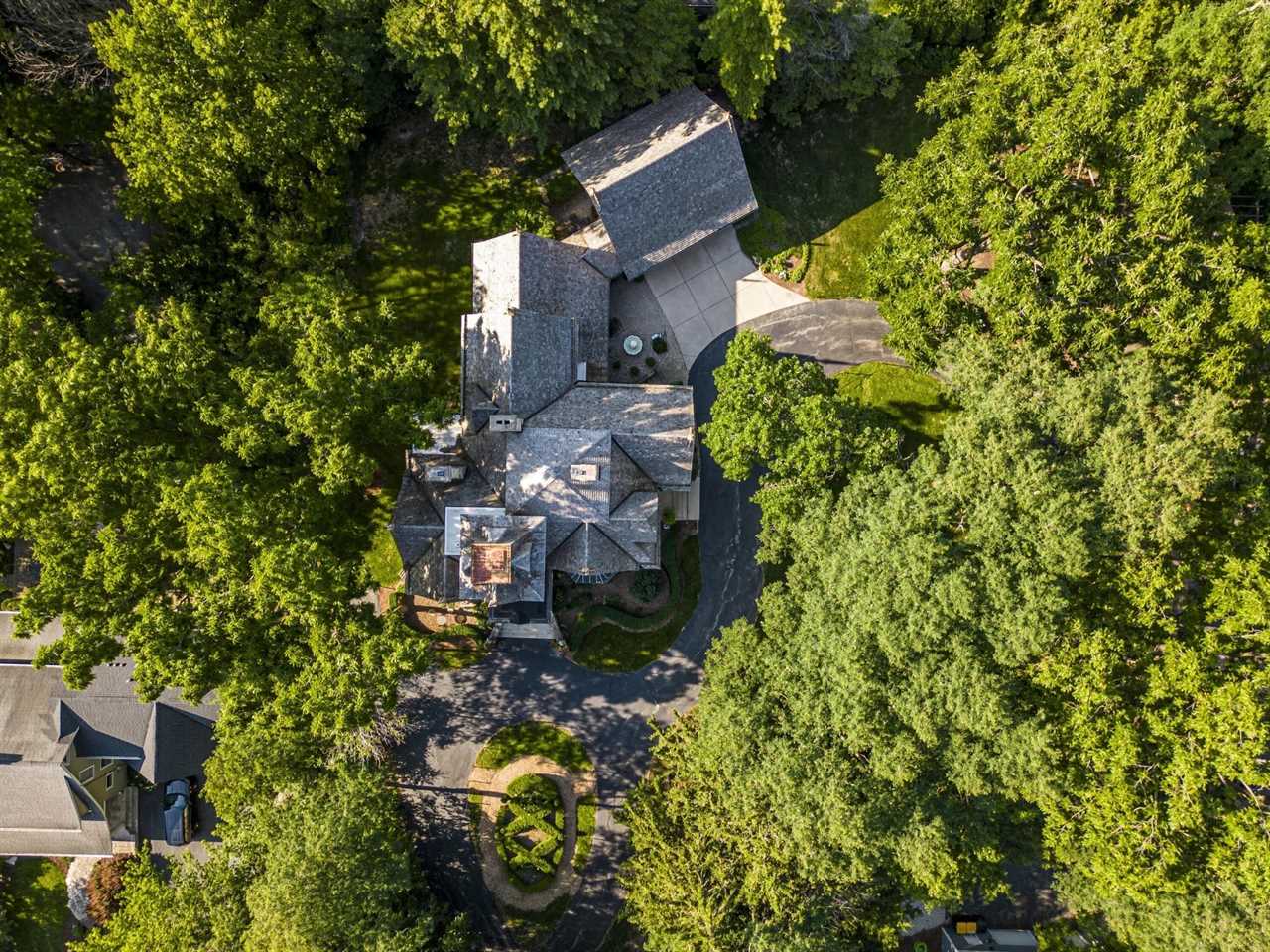 An aerial shot of a mansion surrounded by trees.