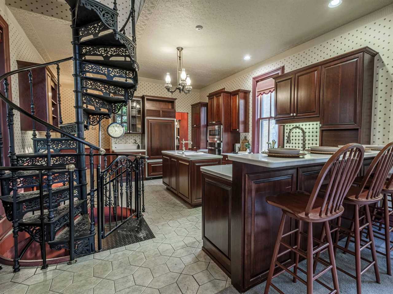 A kitchen with a spiral staircase in it.