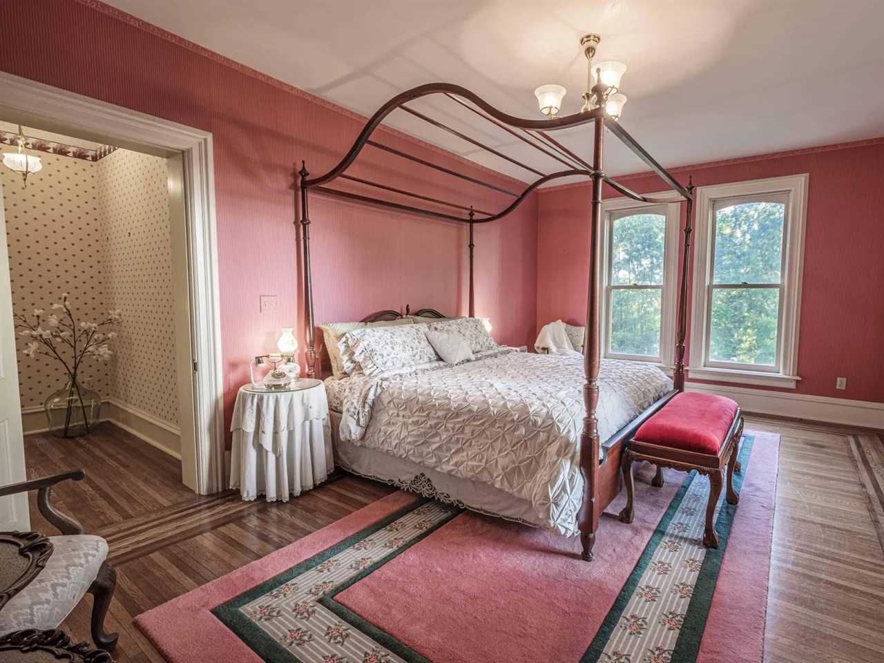 A bedroom with pink walls.