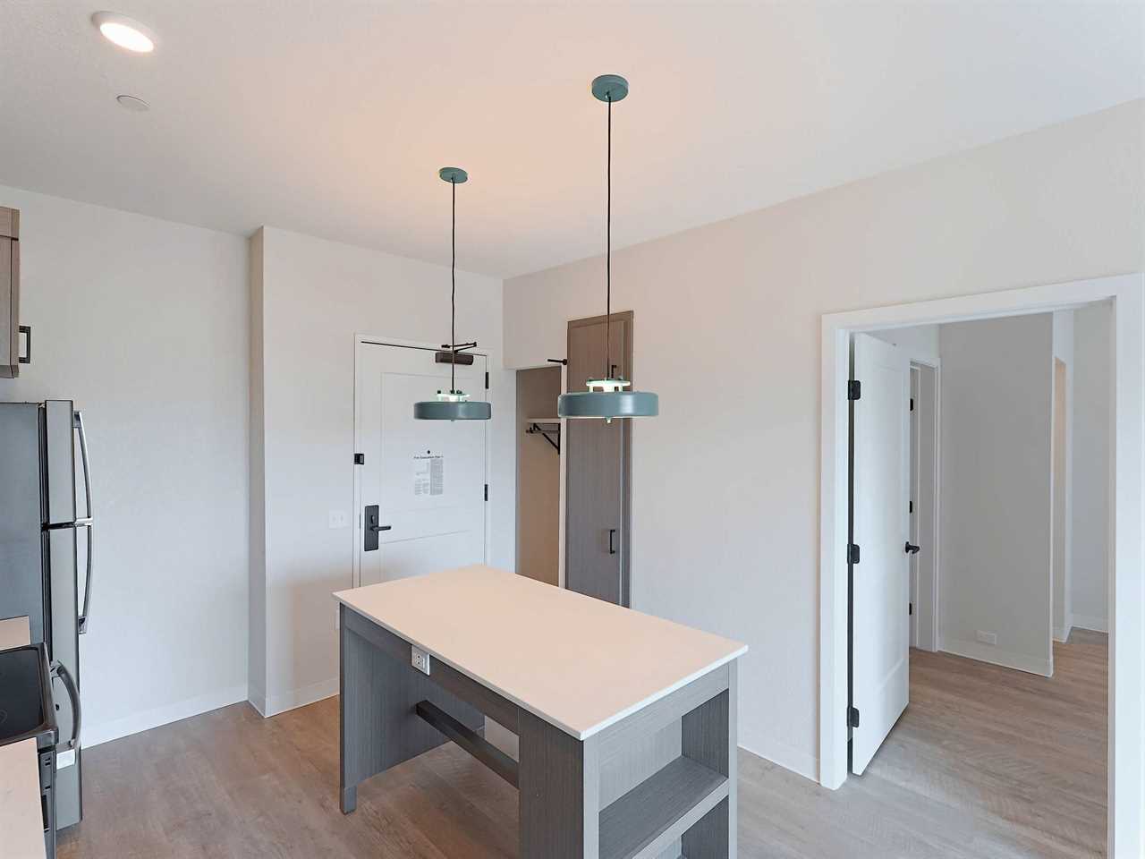 The entry and kitchen of an unfurnished one-bedroom WaterWalk hotel room.