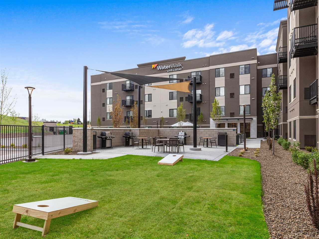 The exterior of the WaterWalk hotel in Meridian, Idaho with a patch of grass and games