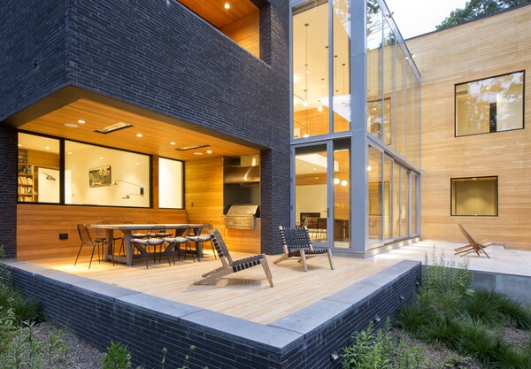 Glass, brick, and wood converge at the home’s central volume. 