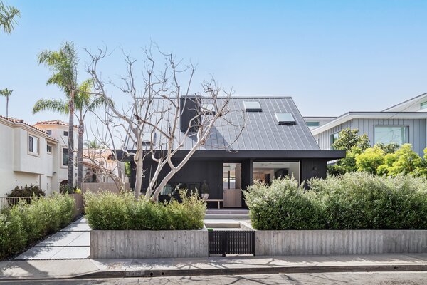 A massive gable roof makes this two-story house appear as if it’s laid out on a single level.