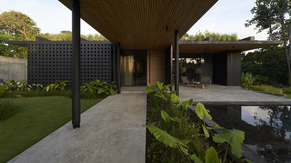 The imposing entrance of the house combines elements of traditional Balinese materials like local Kerobokan stone with international influences such as Shou Sugi Ban Bankiari cladding.