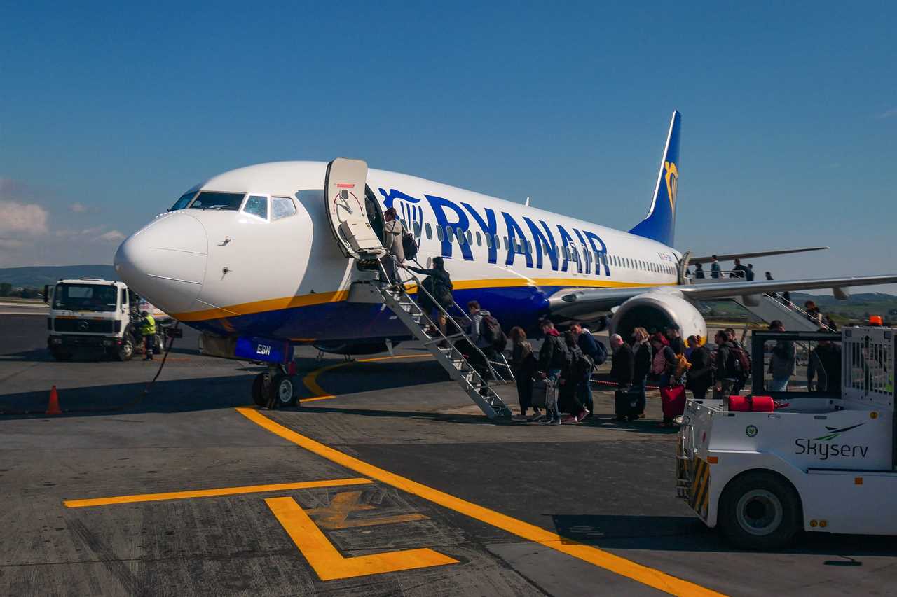 Passengers PAX boarding on a Ryanair FR airplane, the largest low cost budget airline in the Europe at Thessaloniki Makedonia Airport SKG LGTS in Greece. The exterior of a Boeing 737-800 aircraft with registration EI-EBM is seen before the flight on the tarmac. 