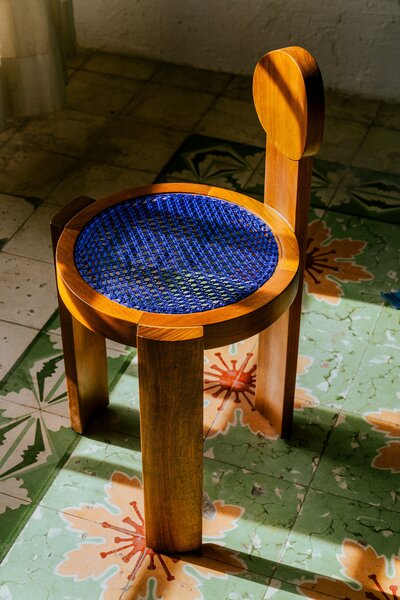 The cobalt blue seat on a chair from Chuch Estudio pops against the muted tones of the original 