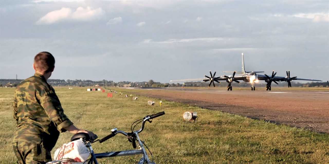 A soldier monitors the runway as a Tu-95 bomber aircraft takes off for a night patrol out of Engels-2 airbase on August 7, 2008 in Engels, Russia