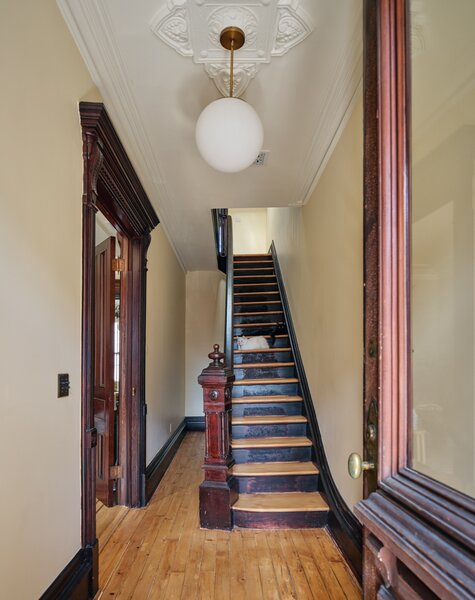 A coat of Benjamin Moore’s Linen White on the walls and White Opulence on the ceiling gave the entry a lift. The pair kept the original oak floors and floor borders, and embraced the existing wood-toned trim.