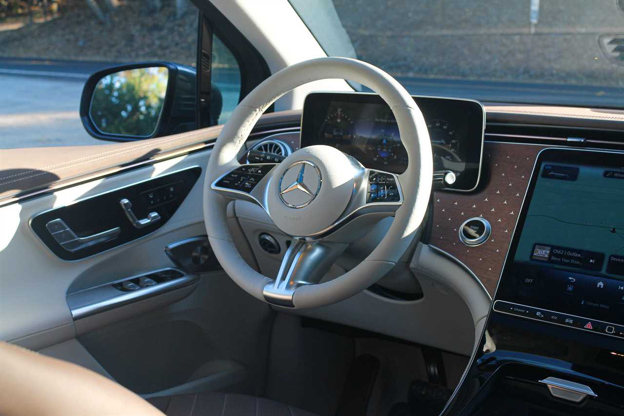 A close up of the white steering wheel in the 2023 Mercedes-Benz EQE SUV electric car. 