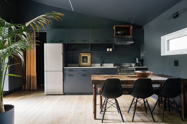 Ample natural light bathes the main living spaces, allowing the wooden accents to pop against the moody toned ceiling and walls.