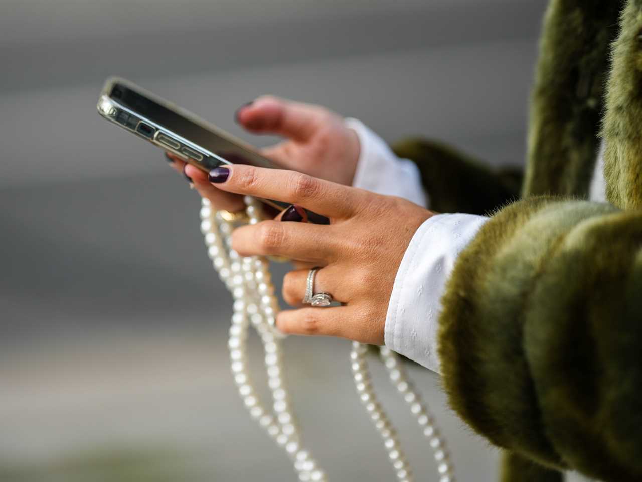 Gabriella Berdugo wears a pale gray wool buttoned cardigan from American Vintage, a khaki long fur coat, during a street style fashion photo session, on November 02, 2022 in Paris, France.