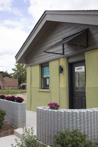 The front porch is surrounded by 3D-print planters, a hint as the construction method for the house itself.