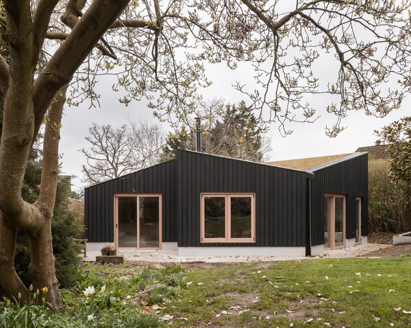 The overall home is constructed with larch timber, a British wood, and features a central ridge beam that gives it a butterfly-shaped roof. Shou sugi ban was done on the wood to give it a charred finish.