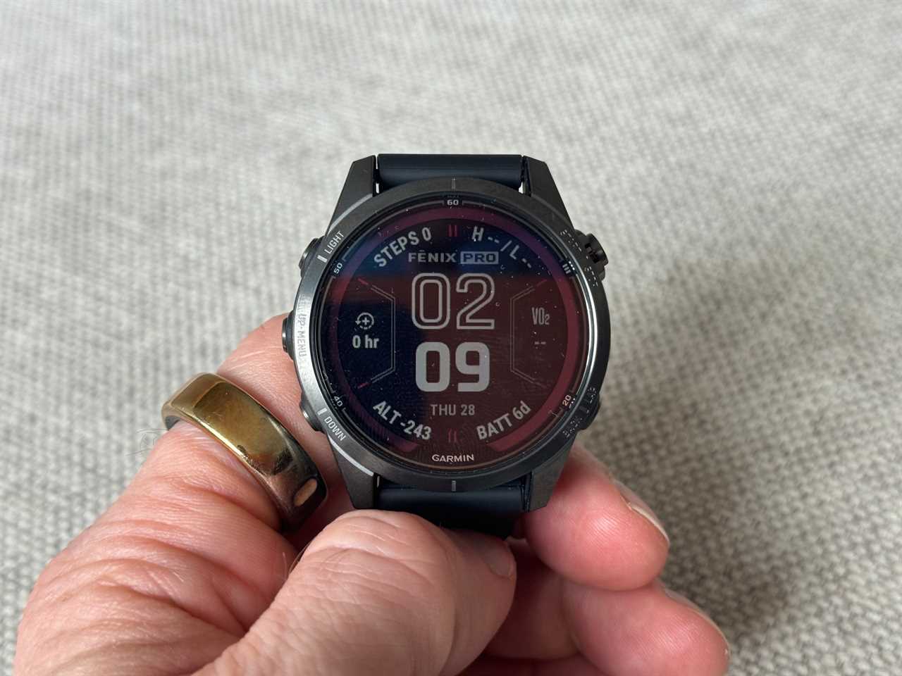 Someone holding a Garmin Fenix 7 Pro smartwatch in their hand.