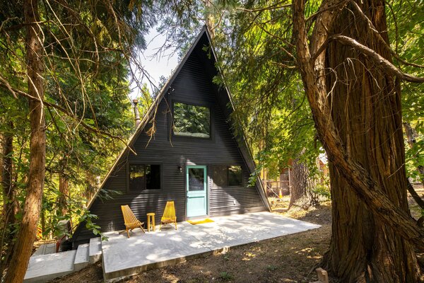 The wood-clad cabin sits back from the road and is encompassed by soaring trees and built-out hiking trails. The popular Lake Gregory is also just a short drive away.