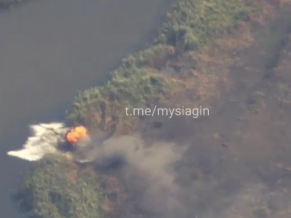 Russian tank on fire falling into body of water.