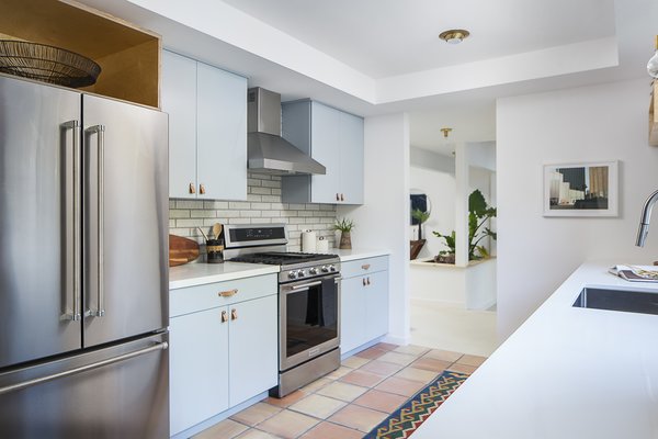 Now, Saltillo floor tiles meld with soft blue cabinetry and a glazed brick tile backsplash.