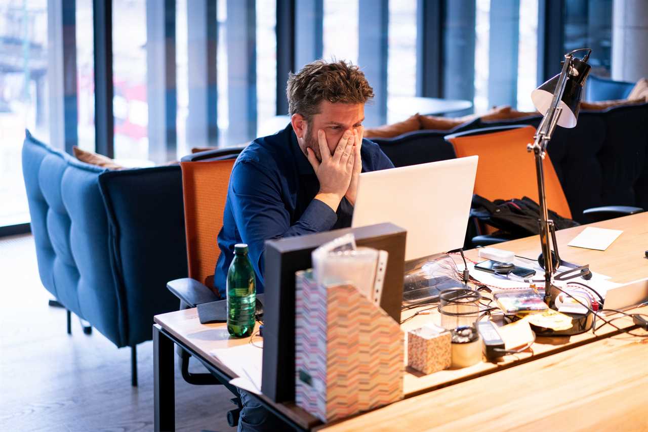 man looking stressed in a messy office