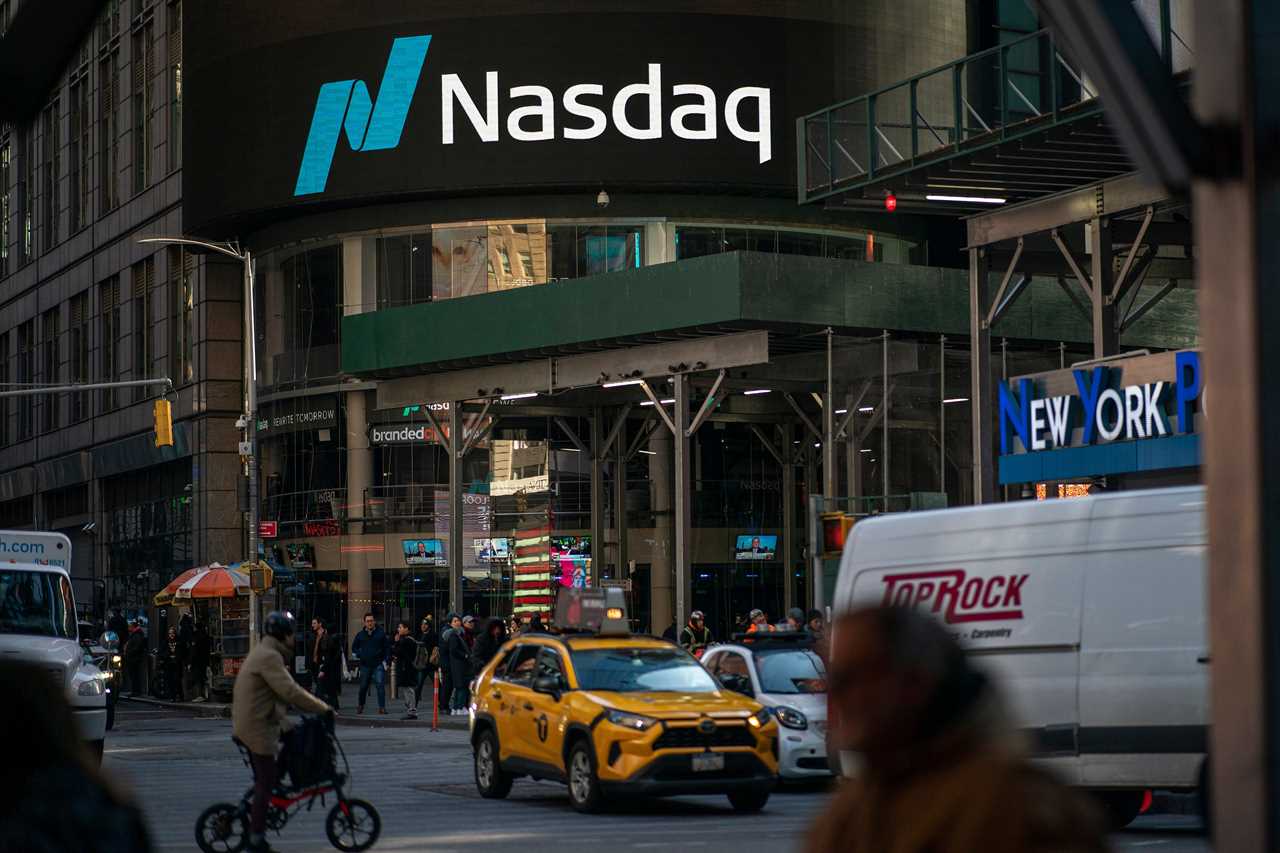 People walk near the Nasdaq building in Times Square on January 24, 2023