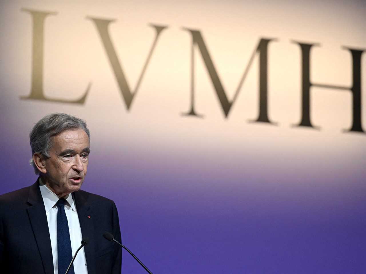 Man standing in a stage talking through a podium microphone.