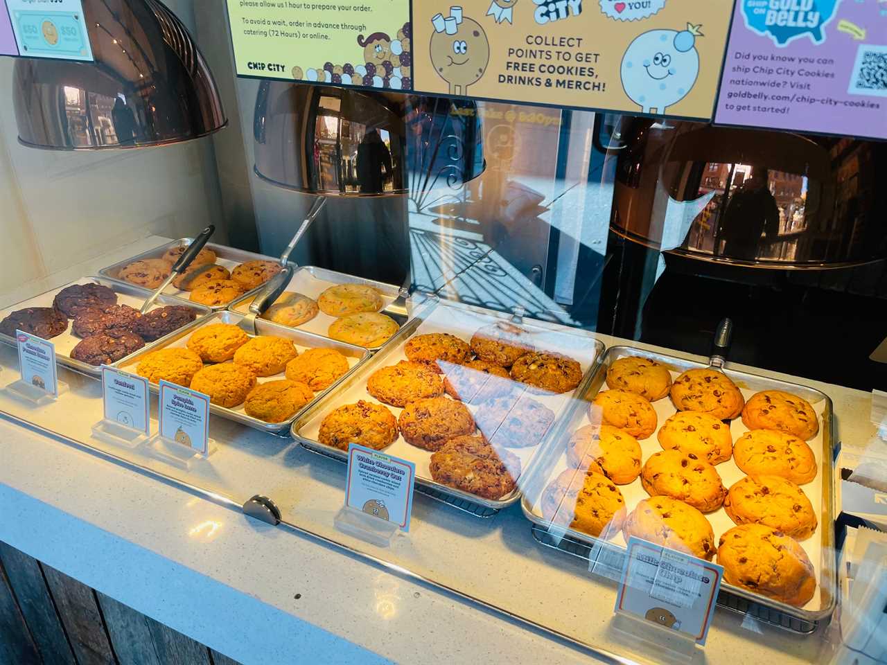 trays of cookies are displayed under heat lamps inside Chip City Astoria