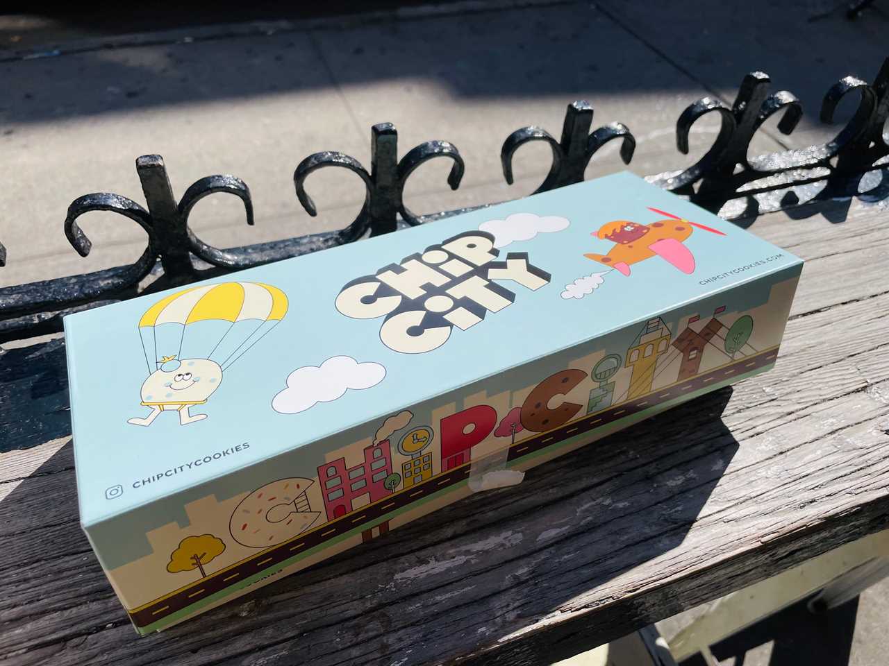 a chip city box sits in the sunlight on a wooden counter outside