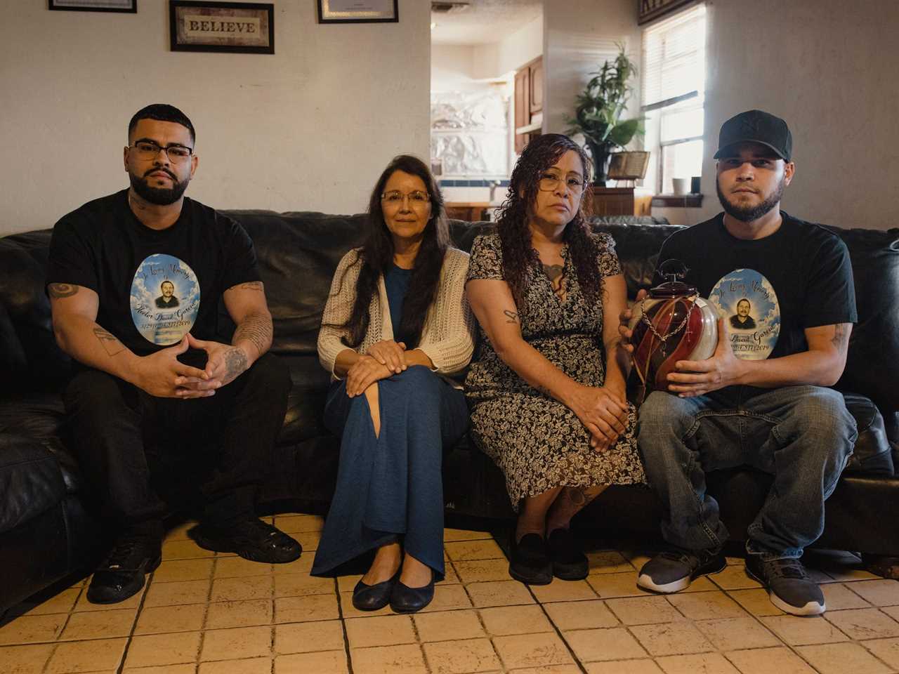 Four members of the Garcia family sit on a couch; one son holds his father's ashes.