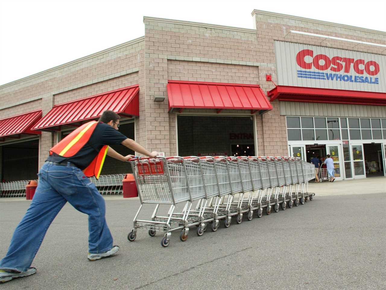 Costco worker pushes carts toward Costco warehouse