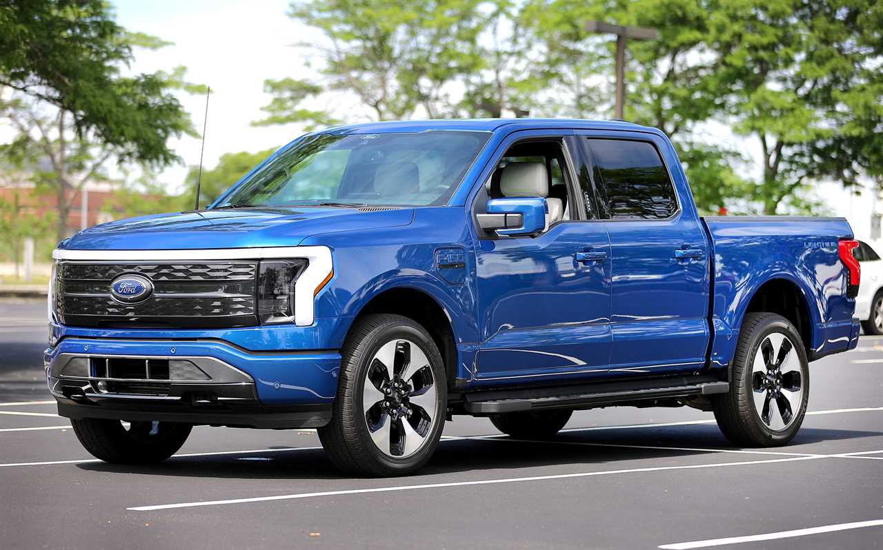 A blue Ford F-150 Lightning on a multi-lane street.