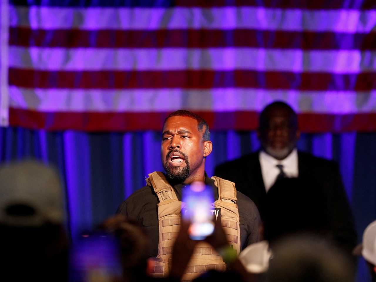 Ye or Kanye West in front of an American flag