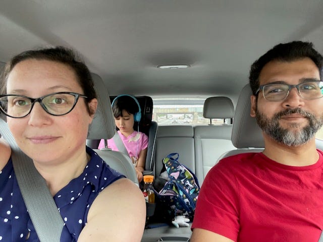 A woman, a man, and a young child inside a car.