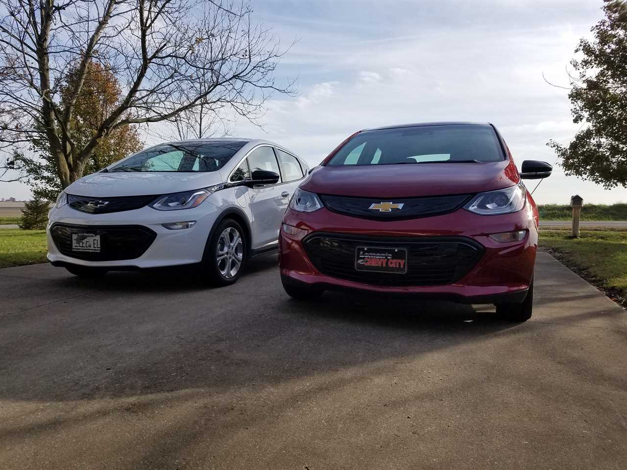 A white car and a red car parked side-by-side.