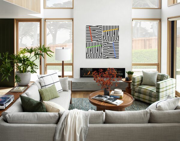 Feldman Architects opened up the living room with a smooth white plaster wall for the fireplace, and a new board-formed concrete hearth. The couch is from Design Within Reach, and the coffee table and side chair are custom.