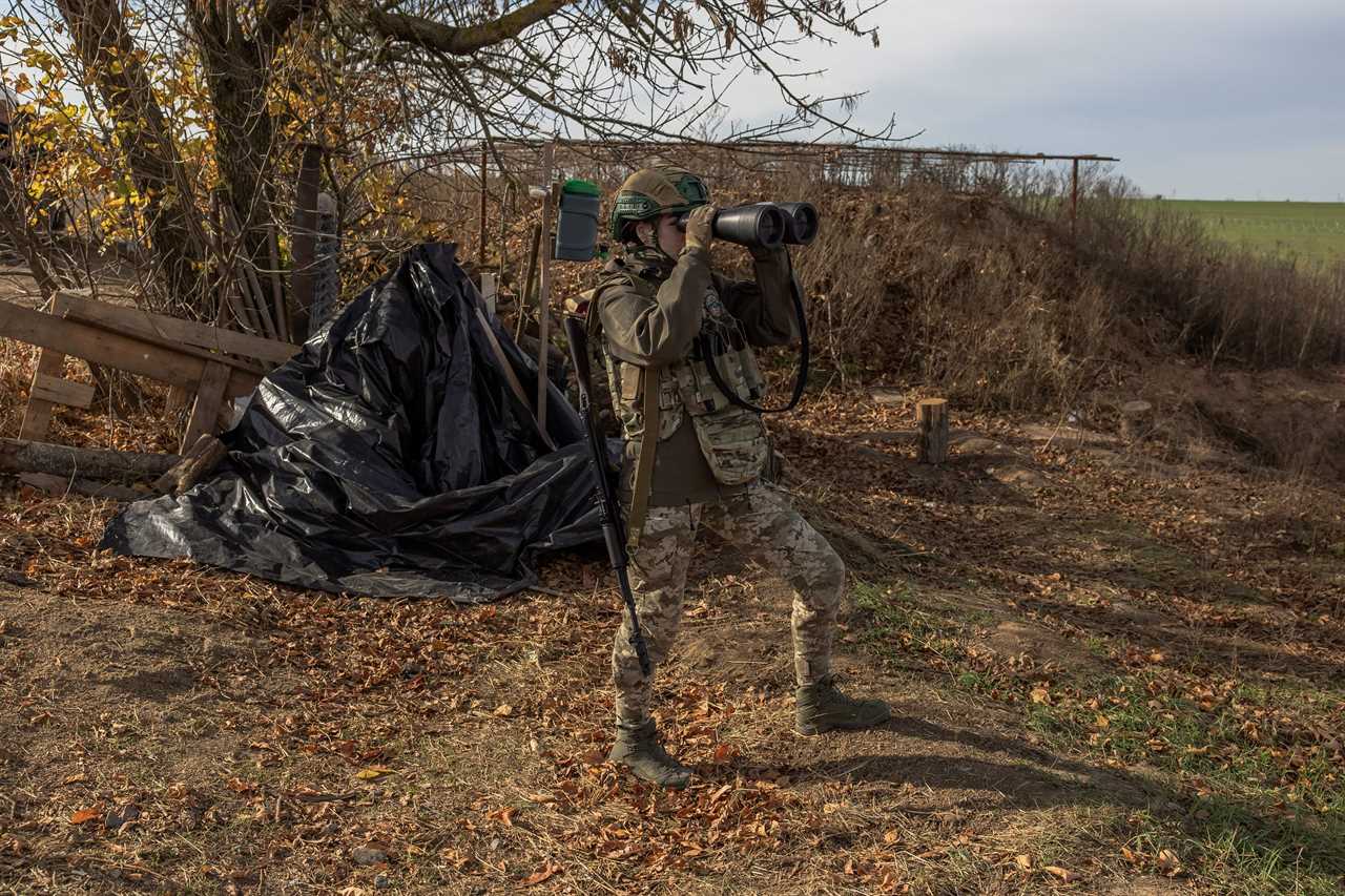 A Ukrainian military member checks the area with binoculars at a position outside the southern city of Kherson, on November 2, 2023.