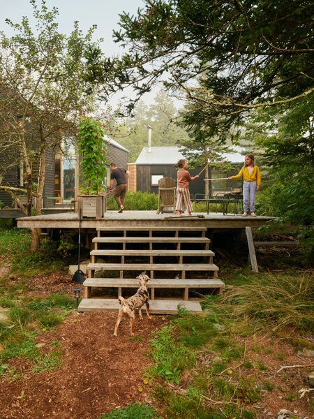 Andrew and Betsy Frederick’s Maine home comprises two volumes with clapboard siding treated with pine tar to preserve it. A deck at the rear of the home leads to floating walkways that hide plumbing.