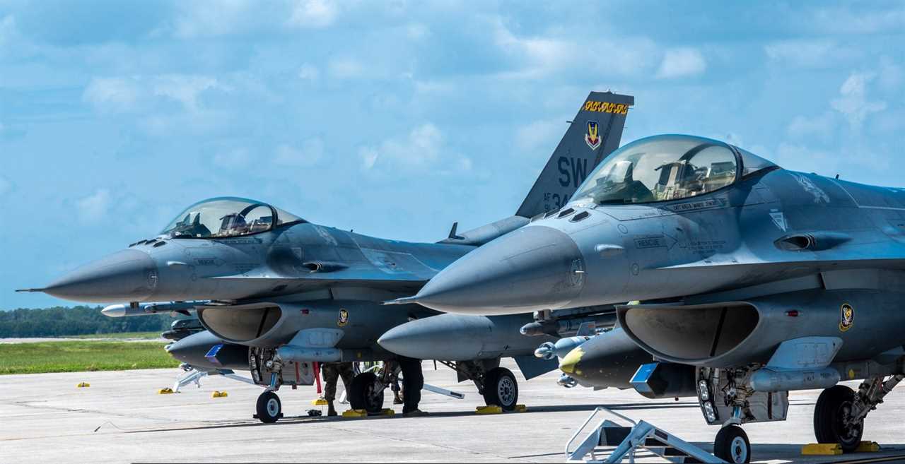 Two US Air Force F-16 Fighting Falcon aircraft sit parked on the flight line at MacDill Air Force Base in 2021.