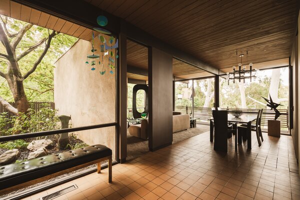 Expansive glazing lining the main living areas presents striking views of the surrounding nature. Sliding glass doors connects the interiors with the front covered terrace.