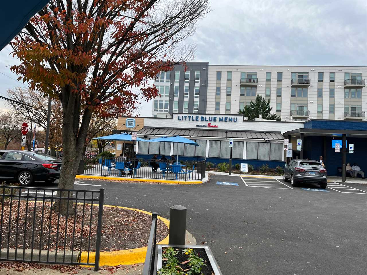 The front of Little Blue Menu in College Park, Maryland, including outdoor seating covered by umbrellas.