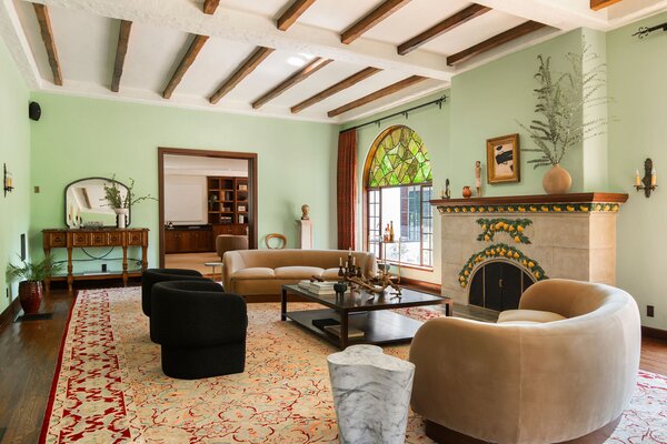 The main living room presents a trove of original details, including Kokomo hand-cast stained glass, hardwood floors, and a decorative citrus fireplace set on a Malibu tile hearth.