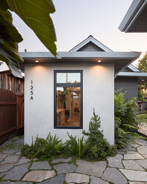 The exterior is mainly stucco, but part of the house is wrapped in shiplap (seen here, painted gray) to better connect it with the property's existing home, which dates back 100 years.