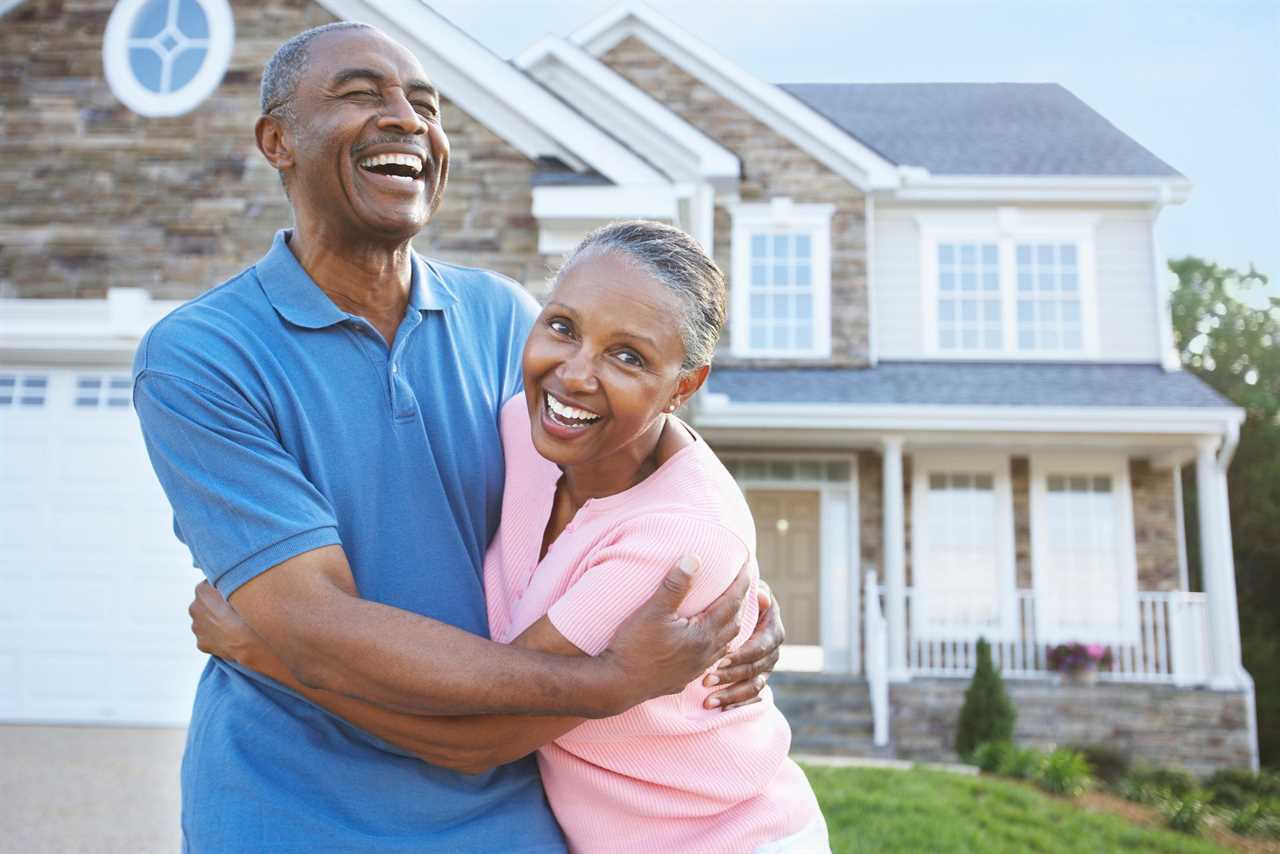 A happy couple outside a house.