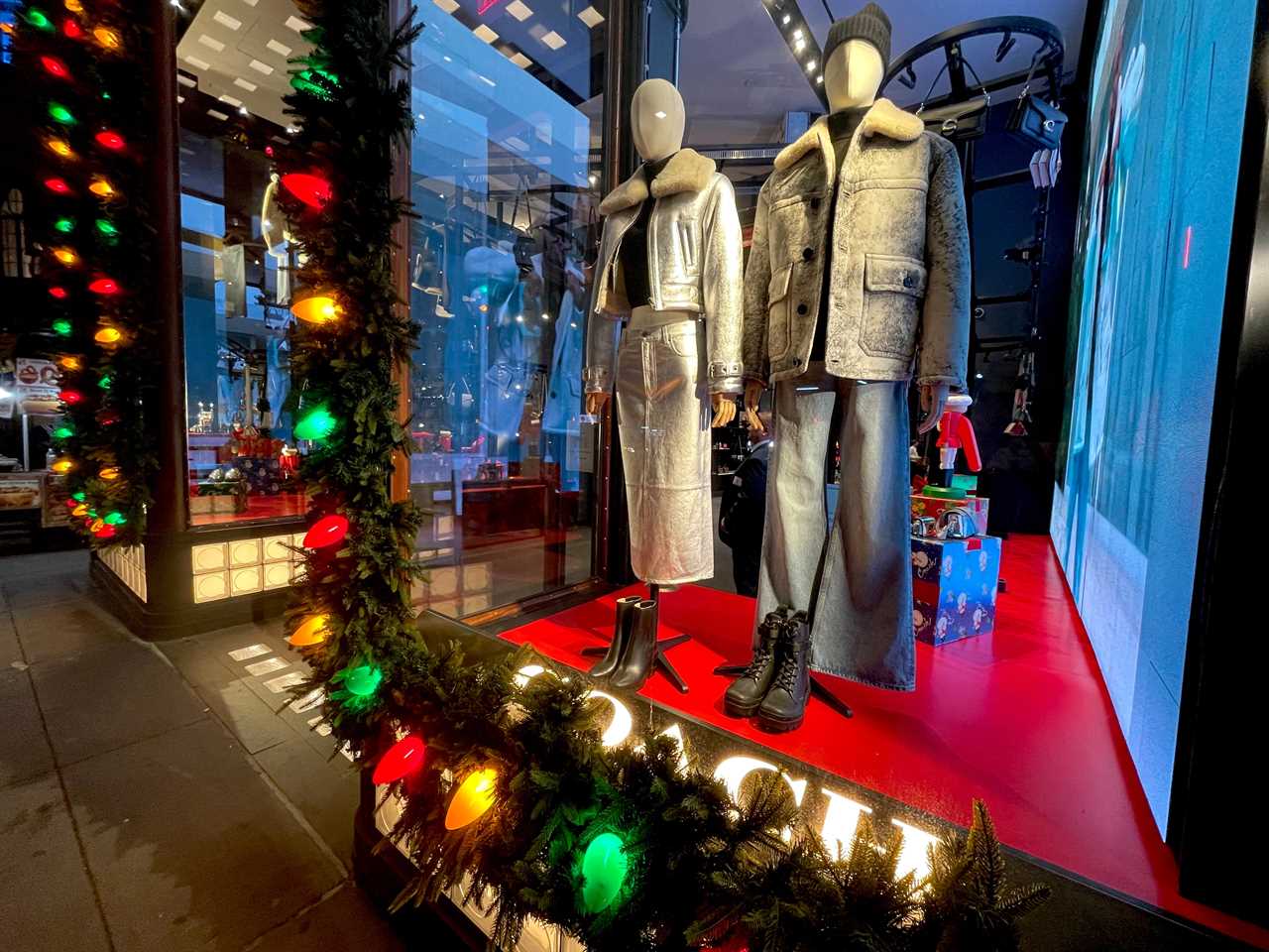 the holiday window at Coach shows mannequins lights and decor