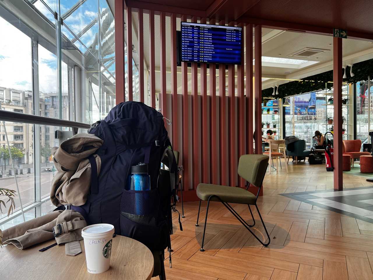 A departure board on the wall of Starbucks in a Paris train station.