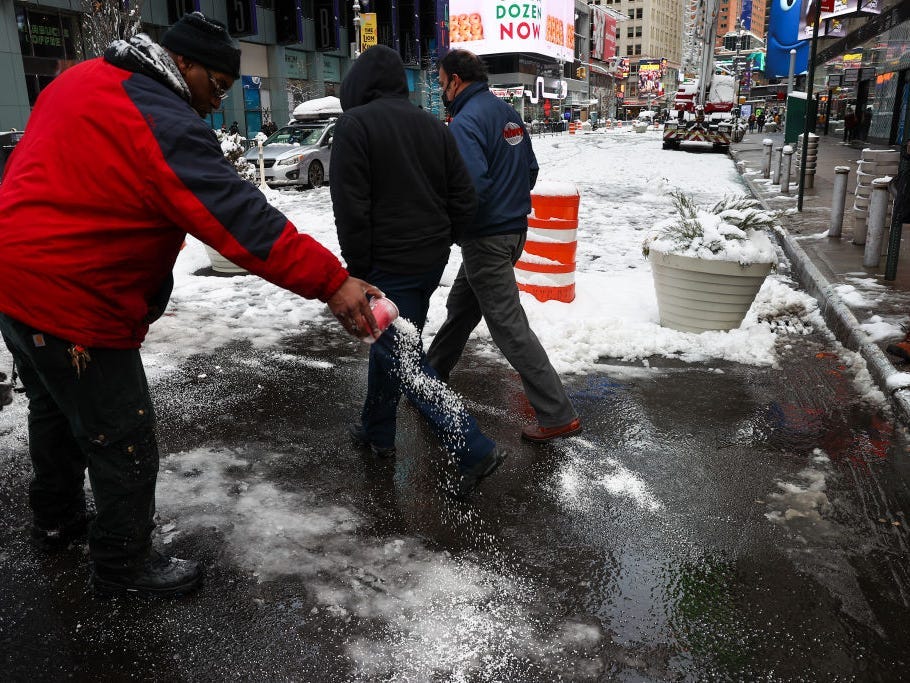 : A worker salting streets as snowfall blankets the Times Square in New York City, United States as massive snow storm hits the east coast.